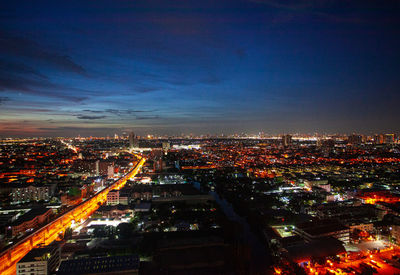 High angle view of illuminated cityscape against sky at night