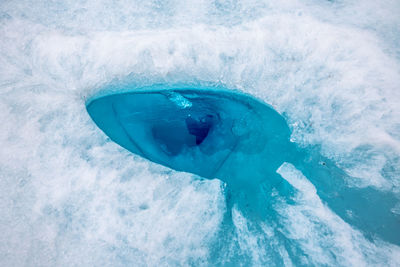 High angle view of water amidst ice in frozen lake