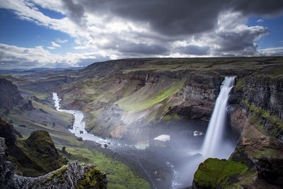 Scenic view of waterfall against sky