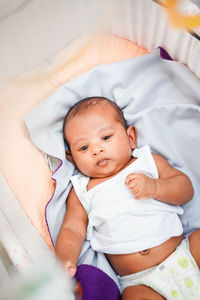 High angle view of baby boy sleeping on bed at home