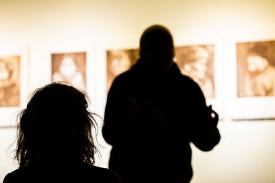 Rear view of silhouette people standing indoors