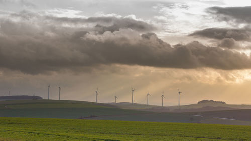 Scenic view of field against cloudy sky