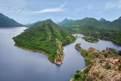 Scenic view of river and mountains against sky