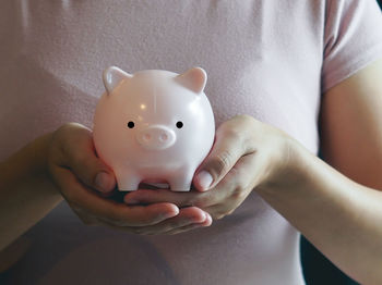 Midsection of woman holding piggy bank