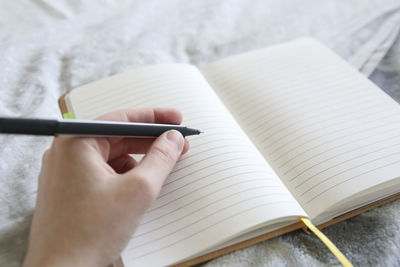 Cropped image of person holding book