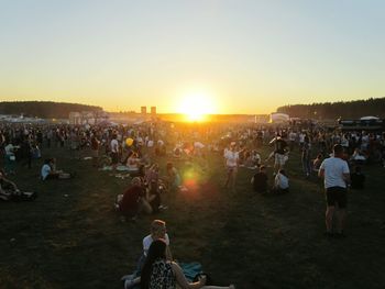 People enjoying at music concert against sky during sunset