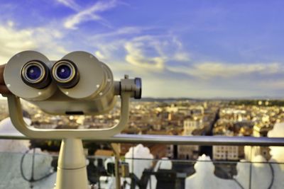 Close-up of coin-operated binoculars against cityscape