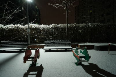 Men sitting on illuminated street at night
