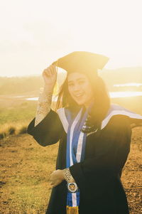 Woman holding umbrella while standing on land against the sky