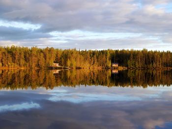 Scenic view of lake by trees against sky