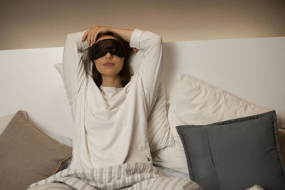 Young woman sitting on sofa at home