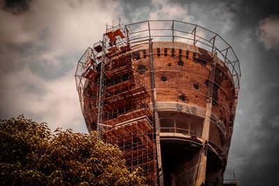 Low angle view of abandoned factory against sky