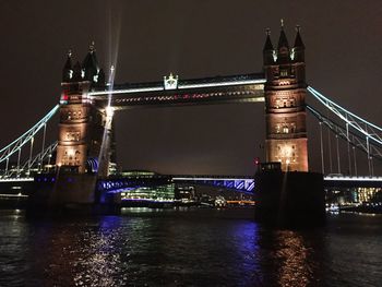 Suspension bridge over river at night