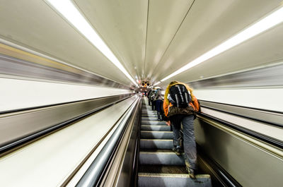 Rear view of man on escalator at subway station