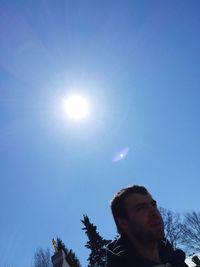 Low angle view of young man against sky on sunny day