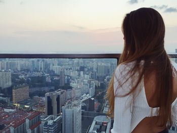 Rear view of woman looking at cityscape