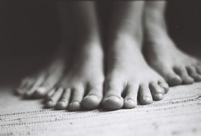 Low section of people with bare feet standing on carpet