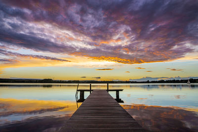 Pier over lake against sky during sunset