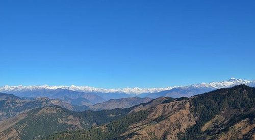 Scenic view of mountains against blue sky