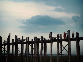 Silhouette fence by railing against sky at dusk