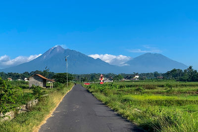 Road leading towards mountains against sky