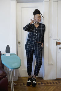 Full length of woman wearing hat while standing on floor at home