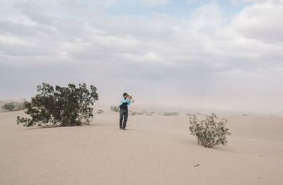 Full length of man standing on sand against sky