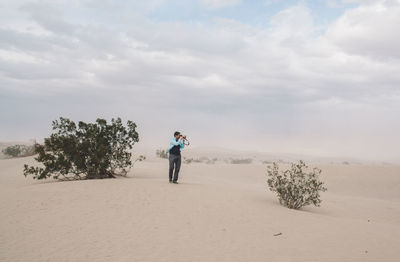 Full length of man photographing in desert