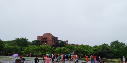 Group of people in front of building against clear sky