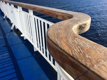 Close-up of wooden railing against sea