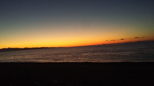 Scenic view of sea against clear sky at sunset