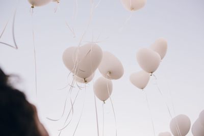 Low angle view of balloons flying against sky