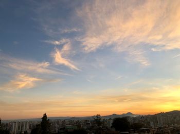 Buildings in city against sky during sunset