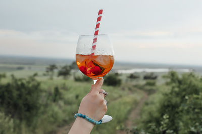 Man holding glass of sea against sky