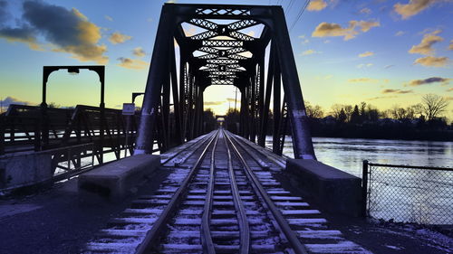 Railway bridge against sky during sunset