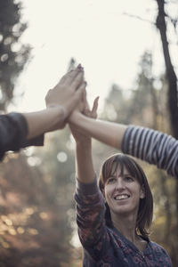 Smiling females doing high five outdoors