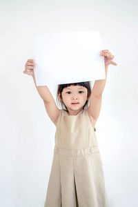 Cute little girl with white sheet of paper. isolated on white background.