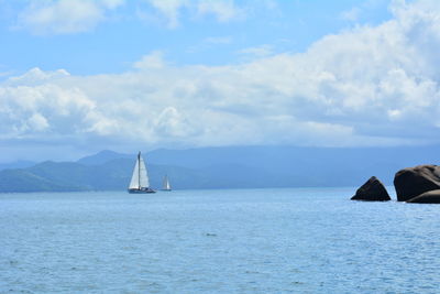 Sailboat sailing on sea against sky