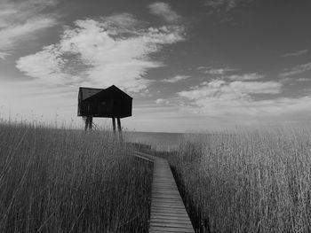 Lifeguard hut on field against sky