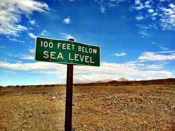 Information sign on landscape against cloudy sky