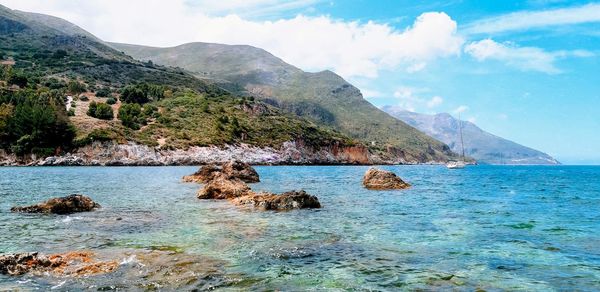 Scenic view of sea and mountains against sky