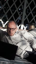 Full length of man sitting on mobile phone