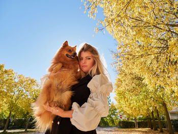 Pretty blond girl play with pomeranian dog