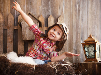 Portrait of happy girl sitting on wood