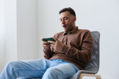 Young man sitting on sofa at home