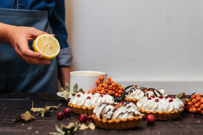 Midsection of man holding fruit on table