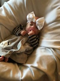 High angle view of newborn baby girl lying on bed