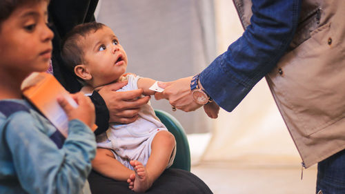 Midsection of man holding baby hand