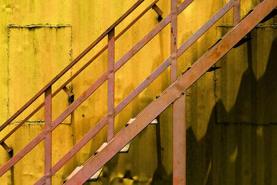 Full frame shot of metal railing against yellow metal wall