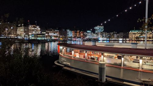 Illuminated bridge over river in city at night